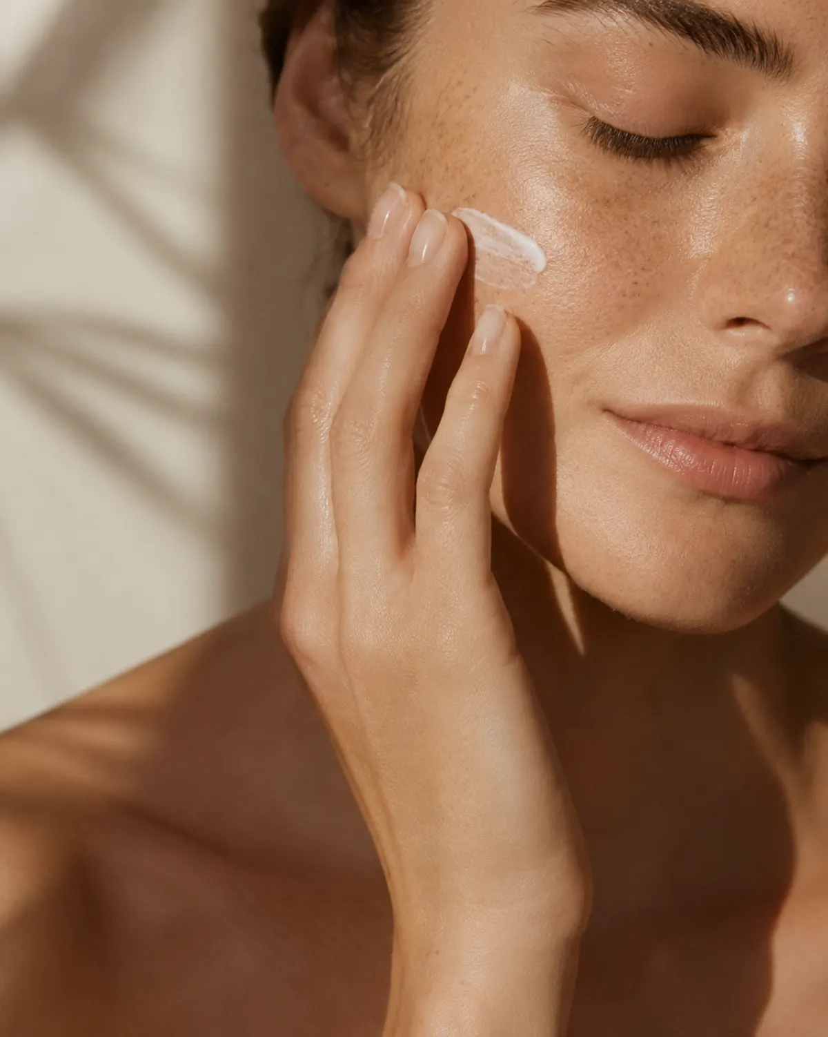 Femme appliquant une crème cosmétique sur le visage